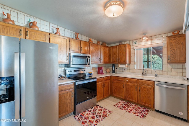 kitchen with sink, stainless steel appliances, light tile patterned floors, and tasteful backsplash