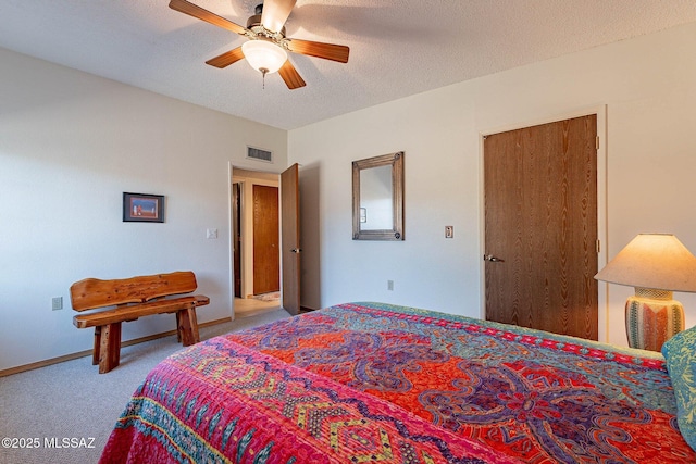 carpeted bedroom with ceiling fan and a textured ceiling