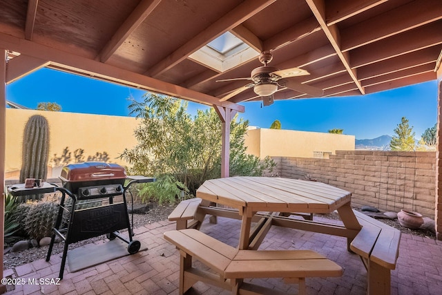 view of patio with ceiling fan, a mountain view, and area for grilling