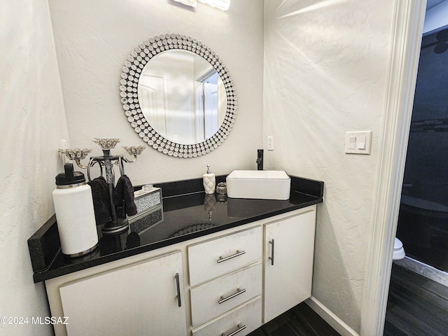 bathroom with vanity, toilet, and wood-type flooring