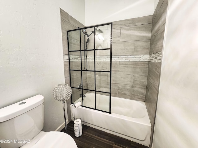 bathroom featuring combined bath / shower with glass door, hardwood / wood-style flooring, and toilet