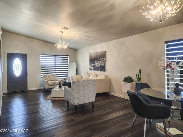 living room with dark wood-type flooring and a notable chandelier