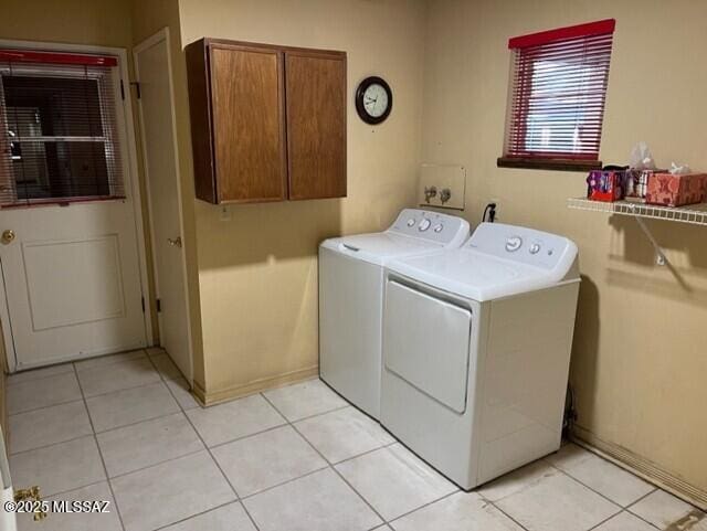 washroom with cabinets, light tile patterned flooring, and washer and clothes dryer