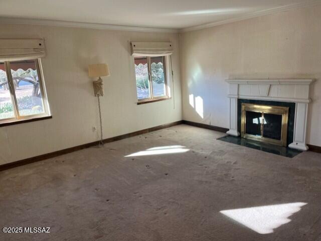 unfurnished living room with a wealth of natural light, ornamental molding, and carpet flooring