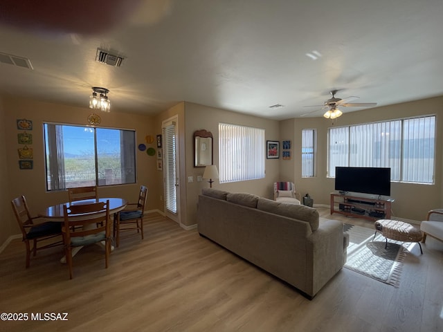 living room featuring ceiling fan, light hardwood / wood-style floors, and a wealth of natural light