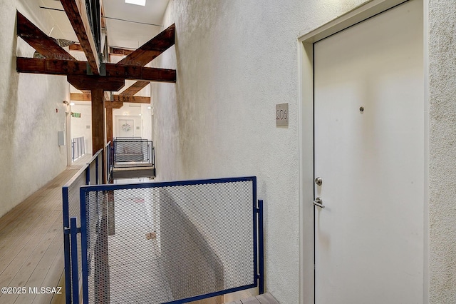 hallway featuring a skylight and beamed ceiling