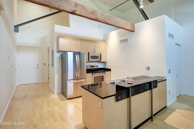 kitchen featuring light brown cabinetry, sink, a high ceiling, stainless steel appliances, and light hardwood / wood-style flooring