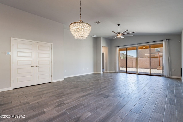 empty room featuring ceiling fan with notable chandelier and lofted ceiling