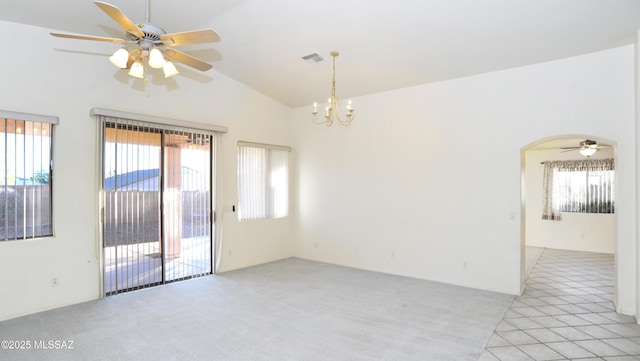 unfurnished room featuring ceiling fan with notable chandelier, light tile patterned flooring, and vaulted ceiling