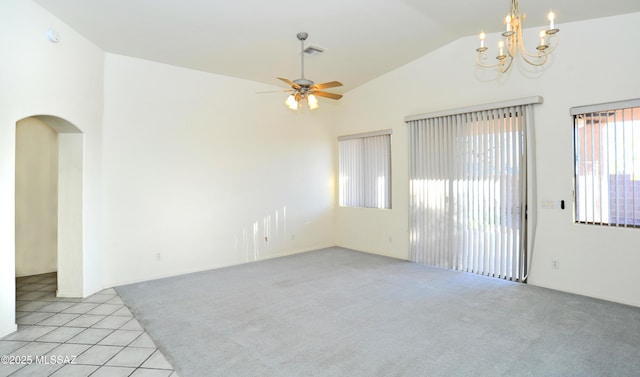 tiled empty room featuring ceiling fan with notable chandelier and vaulted ceiling