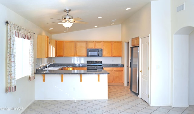 kitchen featuring black appliances, a kitchen breakfast bar, kitchen peninsula, and light tile patterned floors