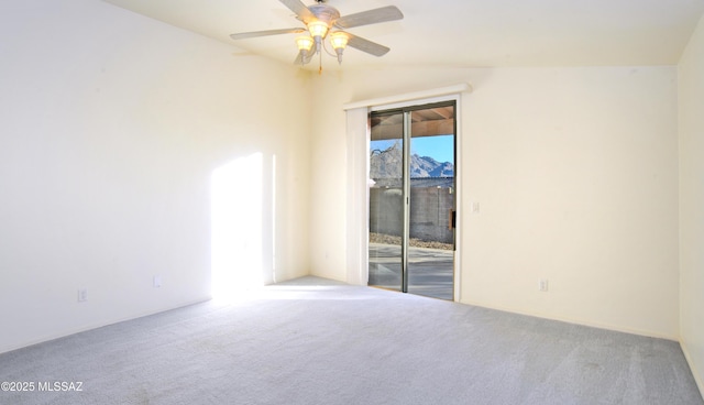 empty room featuring carpet flooring, ceiling fan, and vaulted ceiling