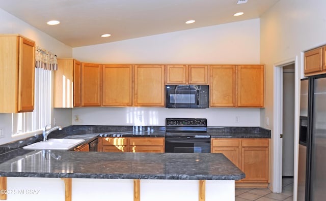 kitchen featuring dark stone counters, kitchen peninsula, sink, and black appliances