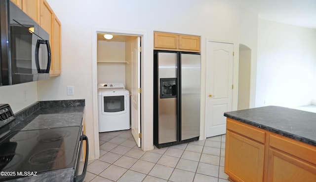 kitchen with light tile patterned floors, washer / clothes dryer, and black appliances