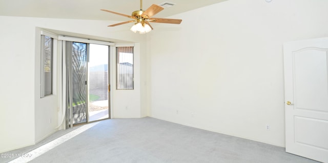 empty room with ceiling fan, light colored carpet, and vaulted ceiling