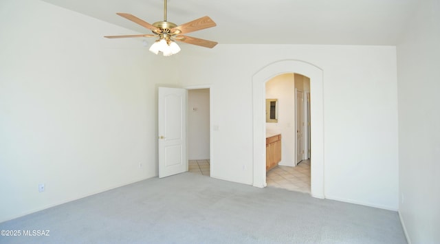 unfurnished bedroom featuring ceiling fan, light carpet, and ensuite bath