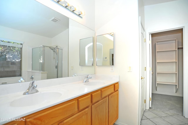 bathroom featuring tile patterned flooring, vanity, and a shower with door