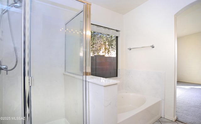 bathroom with tile patterned flooring and separate shower and tub