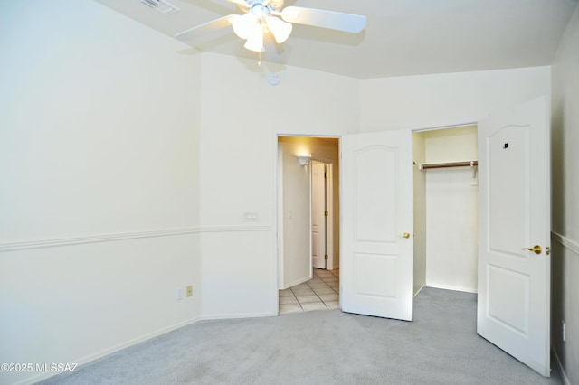 unfurnished bedroom with light carpet, a closet, and ceiling fan