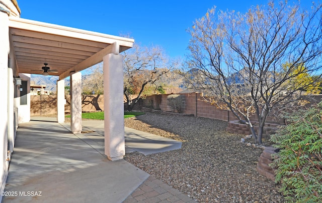 view of yard with ceiling fan and a patio area