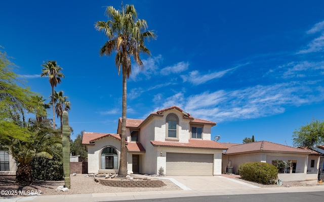 mediterranean / spanish house featuring a tiled roof, an attached garage, driveway, and stucco siding