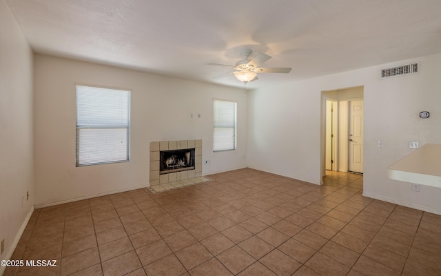 unfurnished living room featuring baseboards, tile patterned floors, a fireplace, a ceiling fan, and visible vents