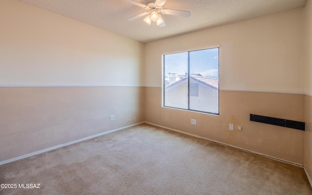 carpeted empty room featuring a textured ceiling, baseboards, and ceiling fan