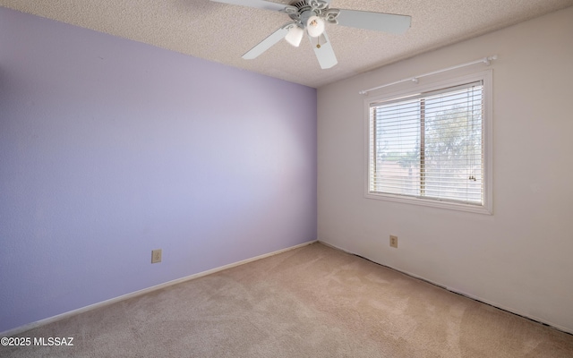 empty room featuring ceiling fan, light colored carpet, and a textured ceiling