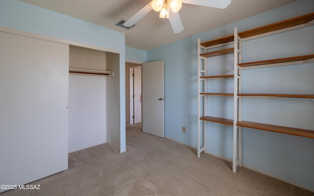 unfurnished bedroom with a closet, carpet flooring, a ceiling fan, and visible vents