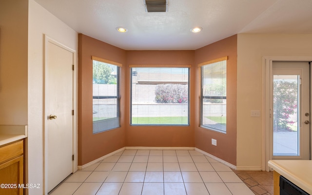 unfurnished dining area with recessed lighting, light tile patterned floors, visible vents, and baseboards