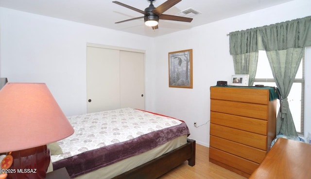 bedroom with a closet, ceiling fan, and light hardwood / wood-style floors