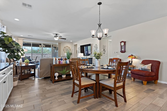 dining space featuring ceiling fan with notable chandelier