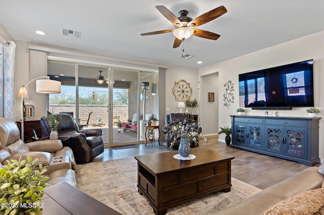 living room featuring ceiling fan and light hardwood / wood-style flooring