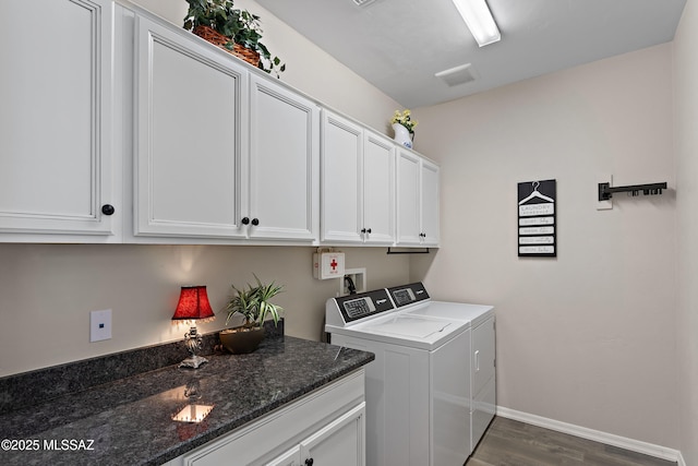 laundry room with washer and dryer, cabinets, and dark hardwood / wood-style flooring