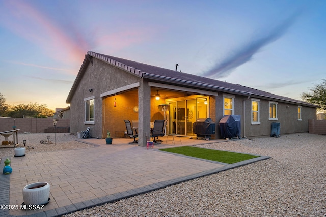 back house at dusk with a patio area