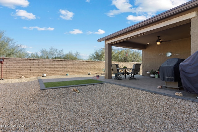 view of yard with ceiling fan and a patio