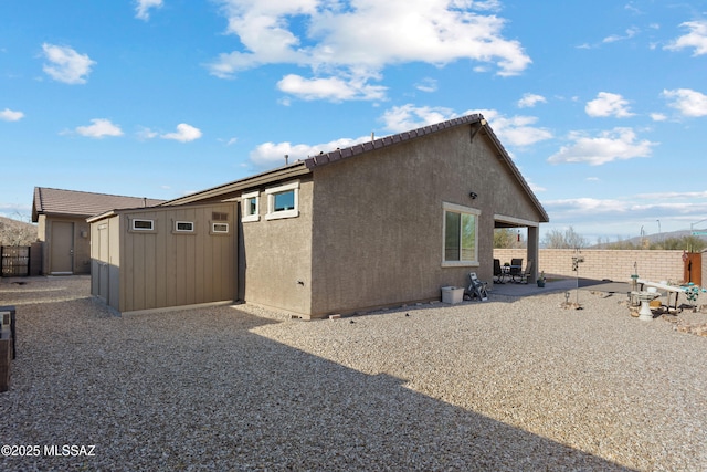 view of side of home with a patio area and a storage unit