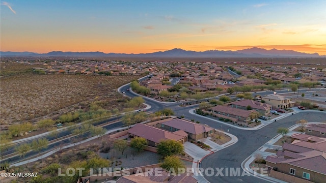 aerial view at dusk featuring a mountain view