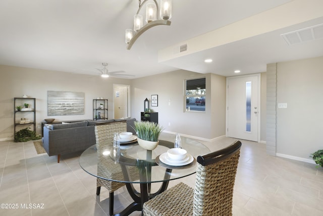 tiled dining room featuring ceiling fan with notable chandelier