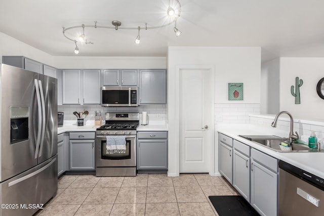 kitchen with light tile patterned flooring, stainless steel appliances, gray cabinets, and sink