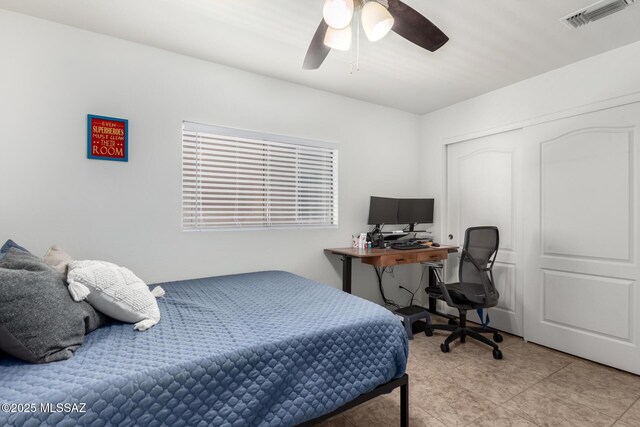 tiled bedroom with ceiling fan and a closet