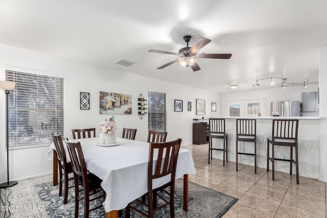 tiled dining area with ceiling fan