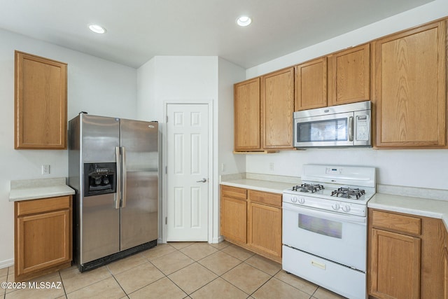 kitchen featuring light countertops, appliances with stainless steel finishes, and light tile patterned flooring