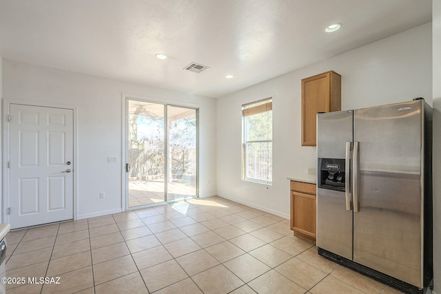 kitchen featuring visible vents, stainless steel refrigerator with ice dispenser, baseboards, and light tile patterned flooring