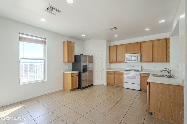 kitchen with visible vents, stainless steel appliances, a sink, and light countertops