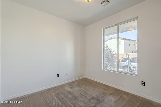 carpeted empty room with visible vents and baseboards