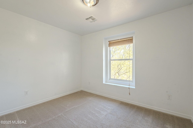 unfurnished room featuring visible vents, light carpet, and baseboards