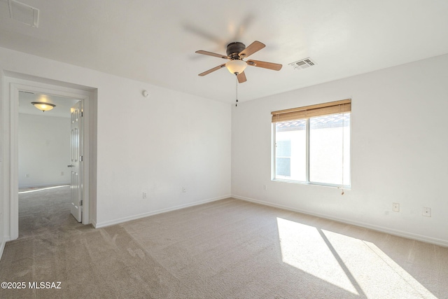 unfurnished room with light carpet, baseboards, visible vents, and a ceiling fan