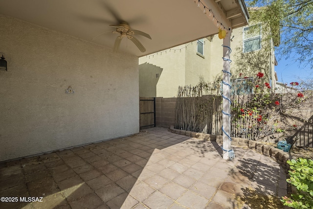 view of patio featuring ceiling fan and fence