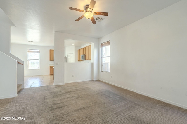 empty room with visible vents, stairway, light carpet, light tile patterned flooring, and baseboards